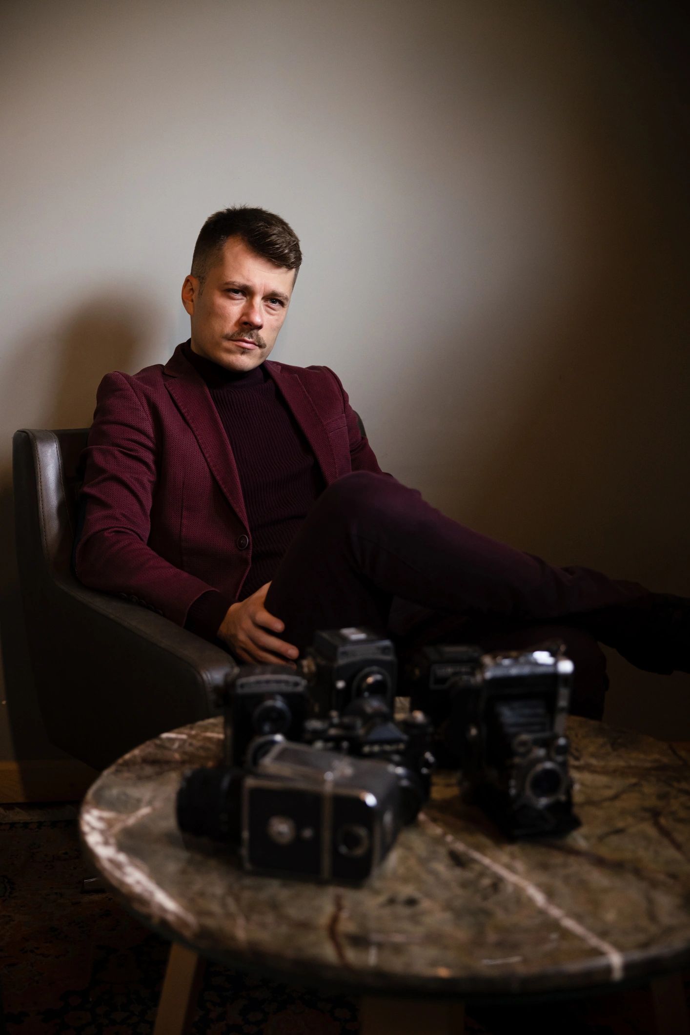 Filmmaker with a collection of analog cameras in a refined studio setting